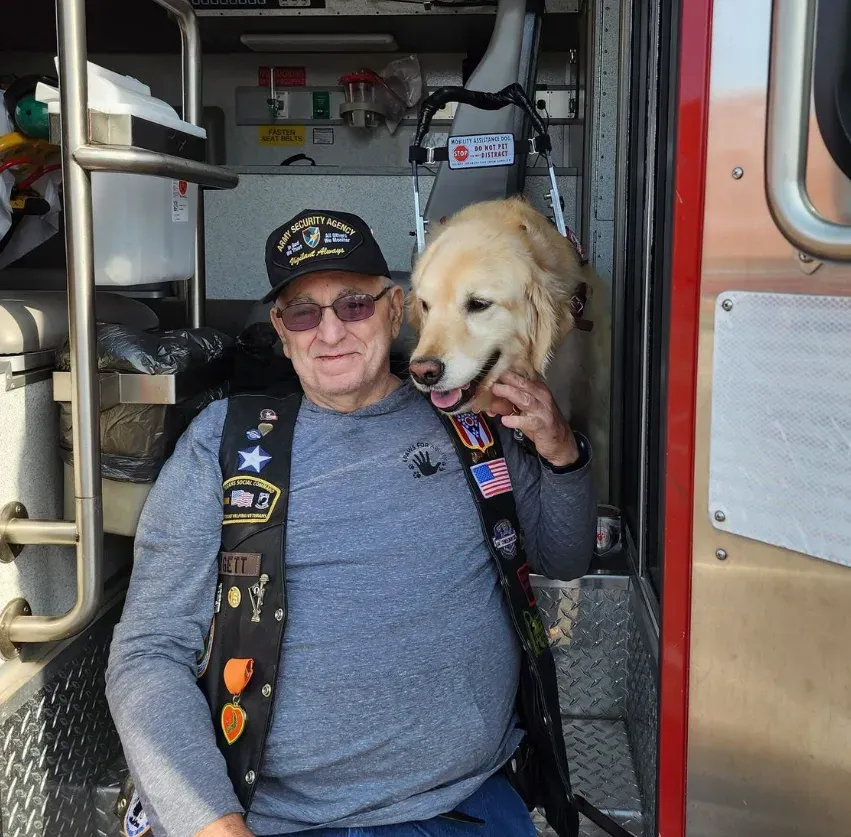 A veteran sitting with his golden retriever service dog